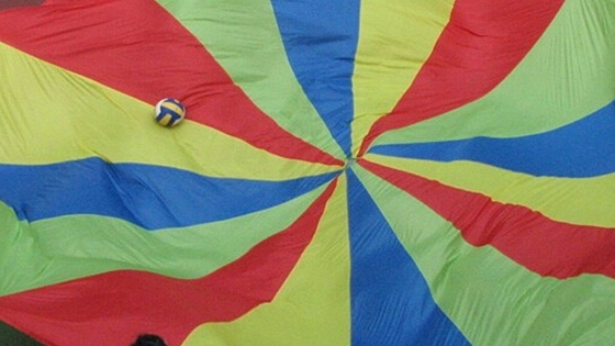 kinderen spelen met bal door middel van parachute