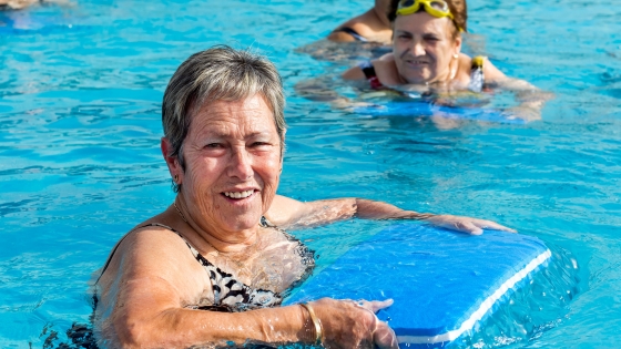 Foto van 50+er die met een plankje oefeningen doet in het zwembad-Aquagym 50+