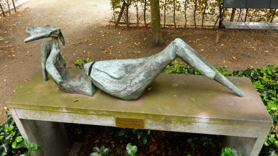 Foto van het kunstwerk van Michel Samyn rustig genieten een steensculptuur die op een bank ligt