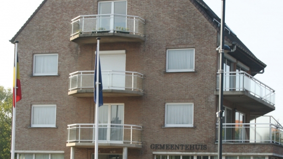 Foto van de zijkant van het gemeentehuis van Gullegem met 3 ramen die een klein balkon hebben