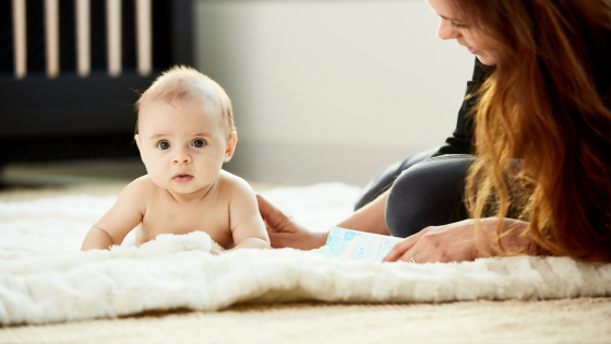 baby en moeder samen op het tapijt
