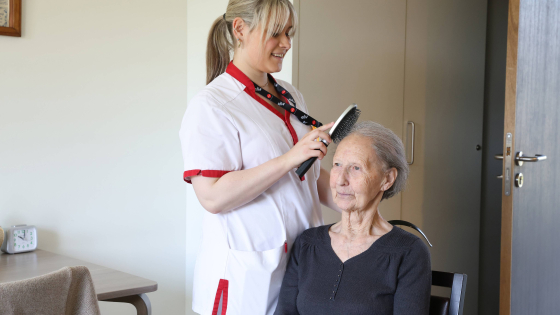 zorgkundige kamt haar van bewoner