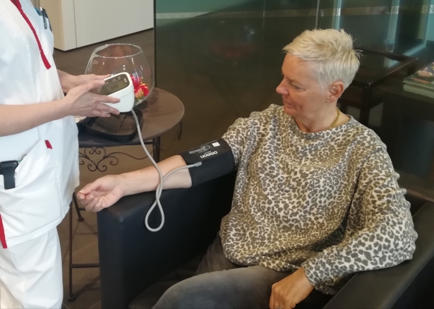 Een verpleger voert een bloeddruktest uit op een bejaarde