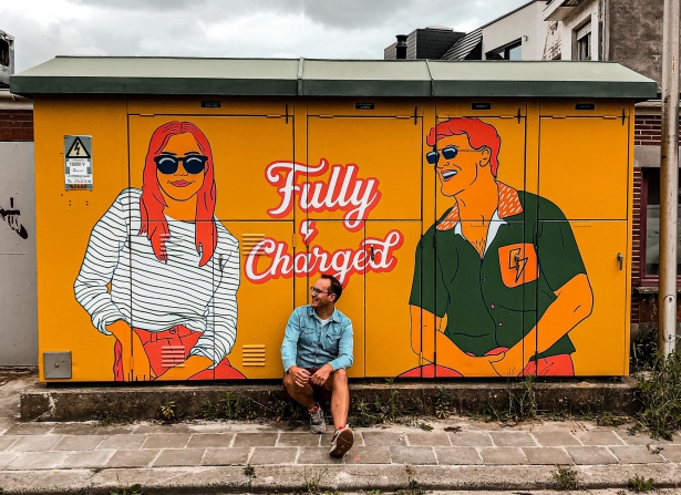 Elektriciteitskast versierd met oranje man en vrouw door Jordy Pype